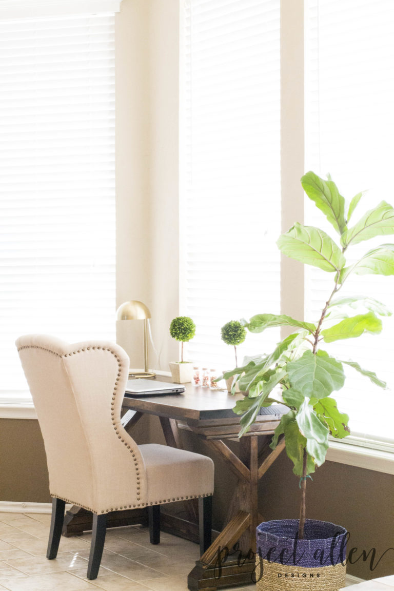 DIY X-leg Desk, fiddle leaf fig , seagrass basket, boxwood topiary. tufted wingback chair, brass table lamp.