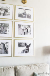 Creating a Grid Style Gallery Wall with these easy tips and tricks. Brass matted picture frames, brass swing arm sconces turned into a gallery wall creates the perfect backdrop for our sofa.