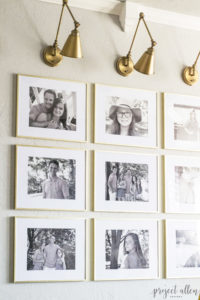 Creating a Grid Style Gallery Wall with these easy tips and tricks. Brass matted picture frames, brass swing arm sconces turned into a gallery wall creates the perfect backdrop for our sofa.