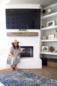 Learn how to paint a brick fireplace with this easy 3 step tutorial. Painted brick fireplace with rustic wood mantle and wall mounted tv, styled built-ins and boho outfit.