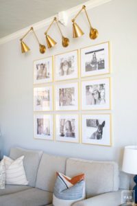 Welcome to our Spring Home Tour: See how we transformed our home with just a few simple changes, a brass frame gallery wall with gold swing arm sconces frame this neutral sofa adorned with mudcloth and leather pillows.