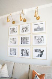 Welcome to our Spring Home Tour: See how we transformed our home with just a few simple changes, a brass frame gallery wall with gold swing arm sconces frame this neutral sofa adorned with mudcloth and leather pillows.