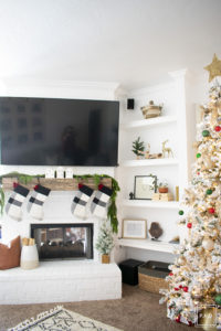 A snowy flocked Christmas tree decorated in red, green and gold gives a big dose of nostalgia to this modern farmhouse living room. 