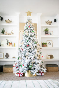 A flocked Christmas tree decorated in red, green and gold gives a big dose of nostalgia to this modern farmhouse living room. 