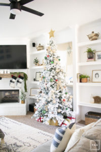 A flocked Christmas tree decorated in red, green and gold gives a big dose of nostalgia to this modern farmhouse living room. 