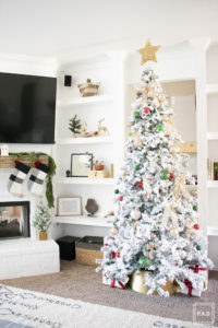 A flocked Christmas tree decorated in red, green and gold gives a big dose of nostalgia to this modern farmhouse living room. 