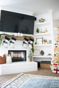 A snowy flocked Christmas tree decorated in red, green and gold gives a big dose of nostalgia to this modern farmhouse living room. 