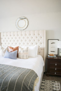 breath of fresh air spring home tour: California cool master bedroom complete with a tufted grand headboard, pattern mixed pillows and tribal rug.