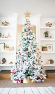 A flocked Christmas tree decorated in red, green and gold gives a big dose of nostalgia to this modern farmhouse living room.